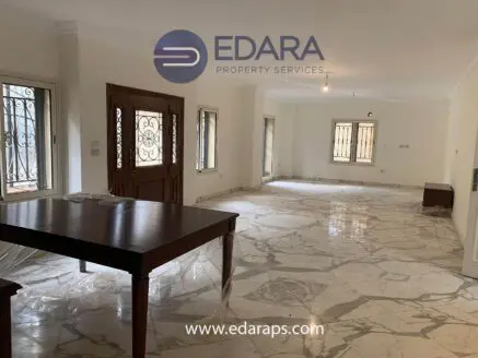 Spacious interior of an unfurnished room featuring marble flooring and large windows.