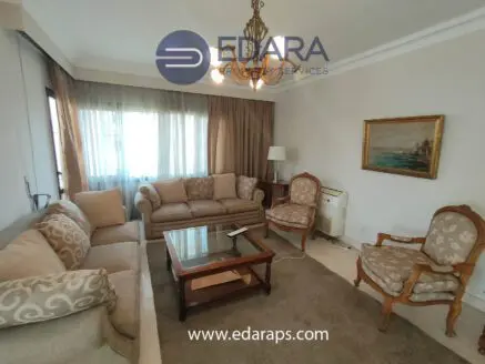 Living room featuring a beige sofa set, wooden coffee table, and decorative armchair in a well-lit space.