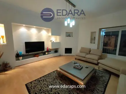 Contemporary living room with a television, sofa, and decorative lighting fixtures.