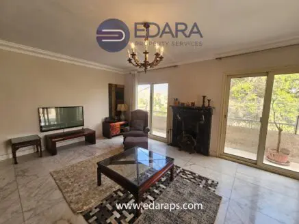 Living room featuring a television, coffee table, and seating area with a chandelier above.