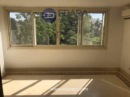 Interior view showing large windows with greenery visible outside in a room setting.