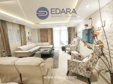 Spacious modern living room with light-colored furniture and decorative elements.