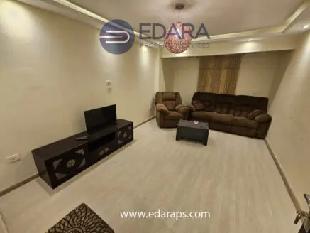 Living room featuring a brown sofa set, a coffee table, and a television on a stand.