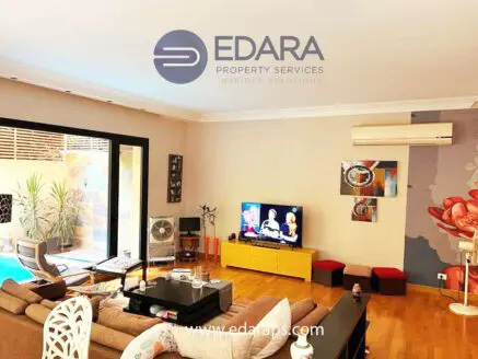 Spacious living room with a television, coffee table, and decorative elements in a contemporary style.