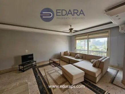 Spacious living room featuring a beige sectional sofa and a television on a stand.