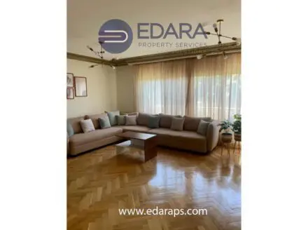 Spacious modern living room featuring a large sectional sofa and a wooden coffee table.