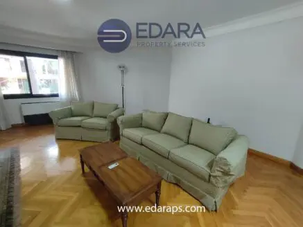 Two light green sofas with a wooden coffee table in a living room setting.