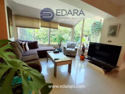 Modern living room featuring a brown sofa, coffee table, and a television on a stand.