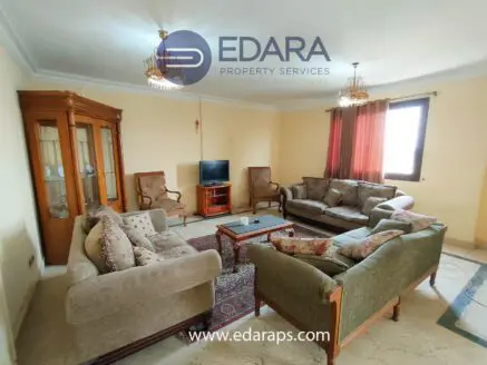 Spacious living room featuring two sofas, a television, and decorative elements in a neutral color scheme.