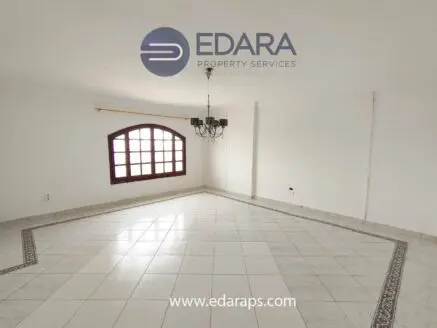 Empty room featuring a chandelier and tiled flooring with decorative borders.
