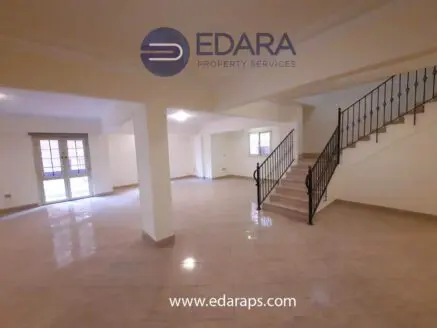 Interior view of a spacious property featuring tiled floors and a staircase.