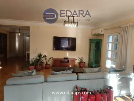 Living room featuring a large television mounted on the wall and a comfortable seating arrangement with plants.