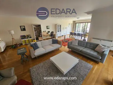 Spacious living room featuring two sofas, a coffee table, and wooden flooring.