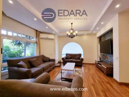 Spacious living room with two sofas, a coffee table, and a wall-mounted television.