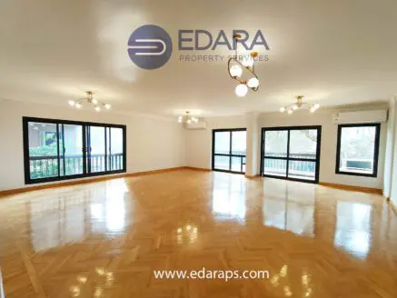 Bright and spacious living room featuring wooden flooring and large windows for natural light.