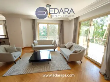 Bright living room featuring two light-colored sofas and a black coffee table on a patterned rug.