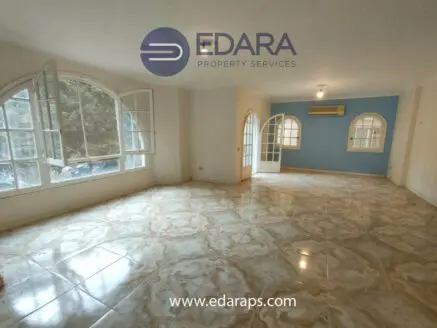 Interior view of a spacious room featuring large windows and tiled flooring.