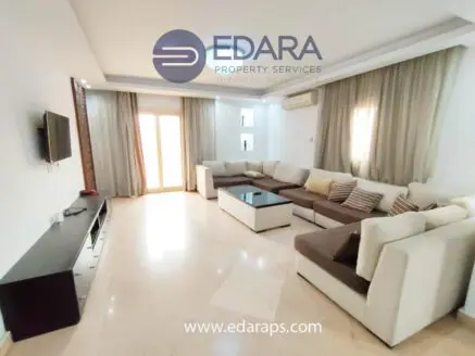 Spacious modern living room featuring a sectional sofa, coffee table, and wall-mounted television.
