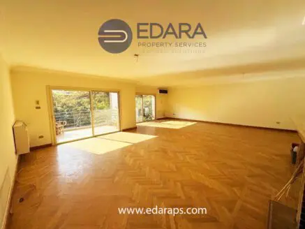 Large living room featuring wooden herringbone flooring and large windows for natural light.