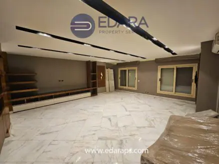 Contemporary living room with marble flooring and wooden shelving units against the wall.