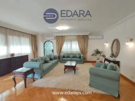 Living room featuring light blue sofas, wooden furniture, and a decorative mirror on the wall.