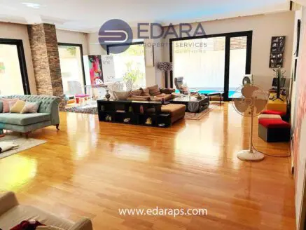 Spacious modern living room with wooden flooring and contemporary furniture arrangement.