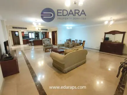 Spacious living room featuring a sofa set, coffee table, and entertainment unit in a well-lit area.