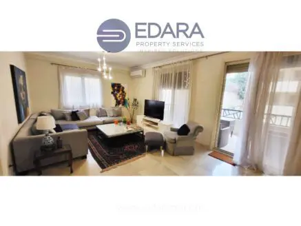 Modern living room featuring a gray sectional sofa, coffee table, and television against a light-colored wall.