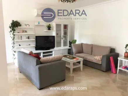 Living room featuring gray sofas, a television unit, and a coffee table in a modern design.