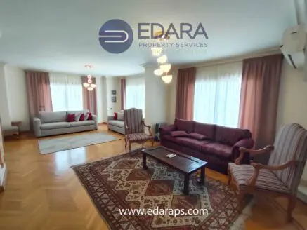 Spacious living room featuring two sofas, a coffee table, and decorative curtains.