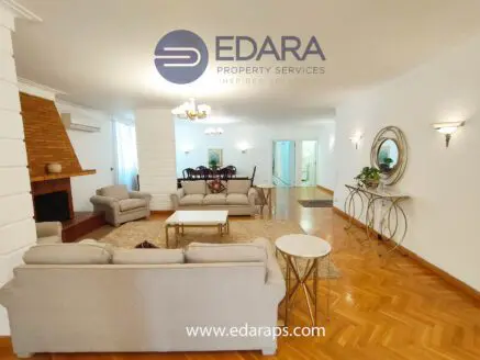 Spacious living room featuring a light-colored sofa set and a coffee table in a well-lit environment.