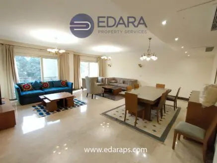 Spacious living room and dining area with modern furniture and decorative elements.