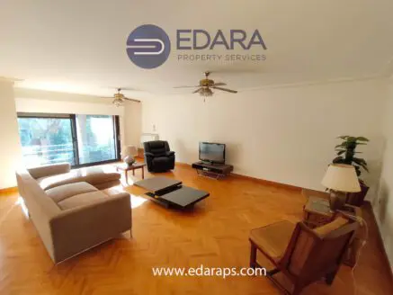 Bright living room featuring a sofa, armchair, coffee table, and ceiling fans in a modern design.