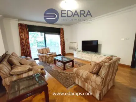 Living room featuring a sofa set, coffee table, and television against a neutral wall.