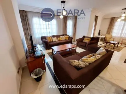 Living room featuring two brown sofas, a coffee table, and a television unit.