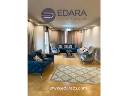 Contemporary living room featuring blue sofas and a decorative rug on wooden flooring.