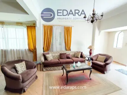 Living room featuring a brown sofa set, coffee table, and decorative curtains in a bright space.