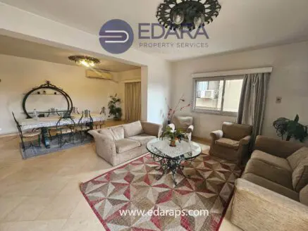 Living room featuring a sofa set, coffee table, and dining area with a decorative rug.