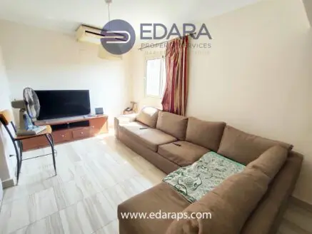 Cozy living room featuring a large sectional sofa and a television on a wooden stand.