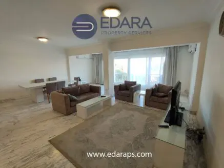 Spacious living room featuring two sofas, a coffee table, and a television on a stand.