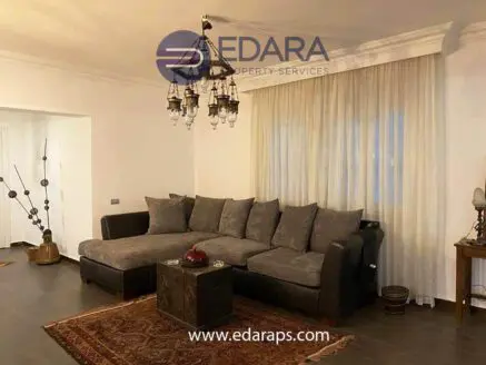 Spacious living room featuring a large sectional sofa and decorative chandelier.