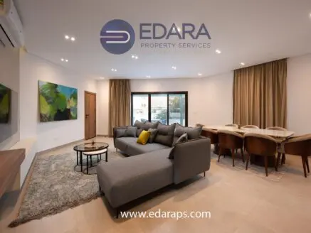 Contemporary living room featuring a gray sectional sofa and a dining table with chairs.
