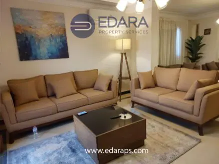 Two beige sofas with wooden legs and a coffee table in a contemporary living room setting.