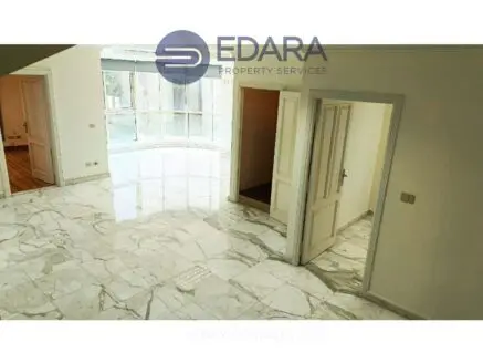 Interior space featuring marble flooring and white walls with doorways leading to adjacent rooms.