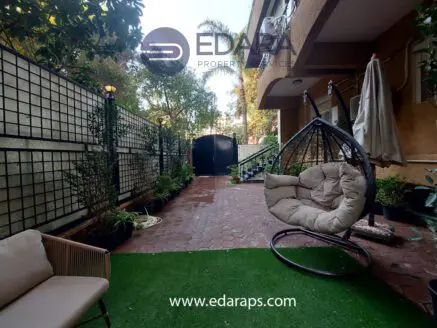 Outdoor seating area featuring a hanging chair and potted plants in a residential setting.