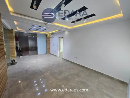 Modern interior room with tiled flooring, recessed lighting, and wooden accents on the walls.