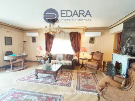 Living room featuring classic furniture, a chandelier, and decorative elements in a warm color palette.