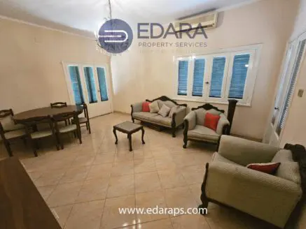 Interior view of a living room featuring a sofa set and dining table with chairs.