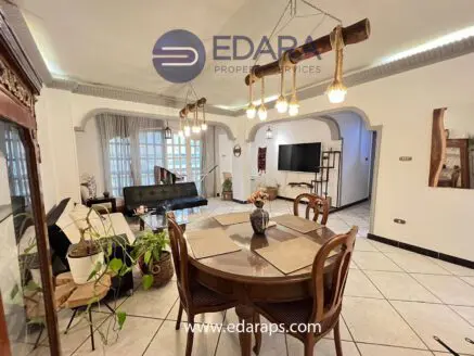 Spacious living room featuring a dining table, modern furniture, and decorative lighting fixtures.