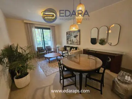 Modern living room featuring a round table, chairs, and decorative lighting fixtures.